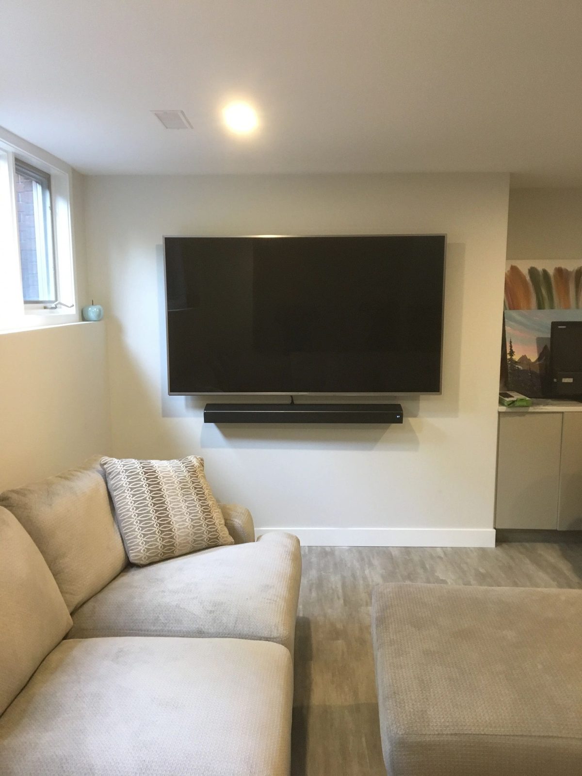 Wall mounted TV with soundbar above a low console