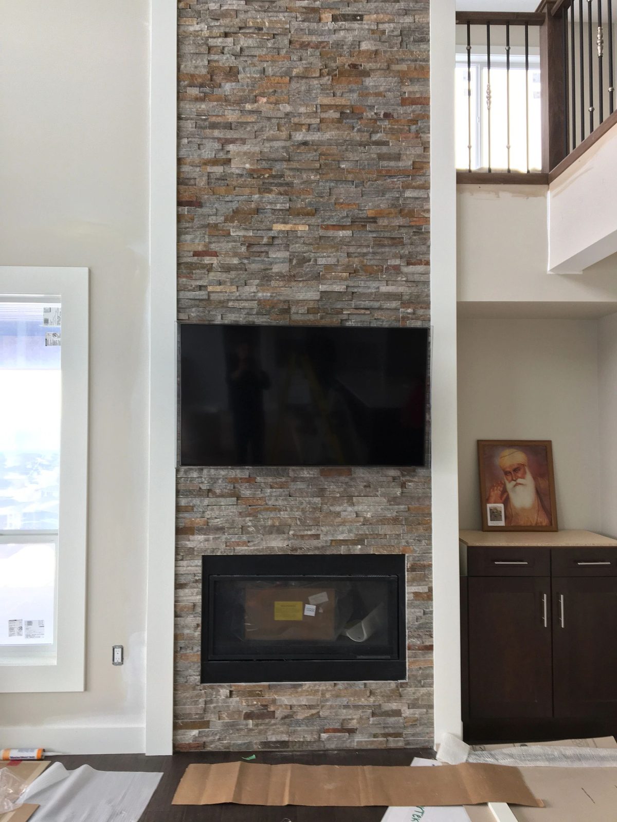 TV mounted on a stacked stone chimney breast