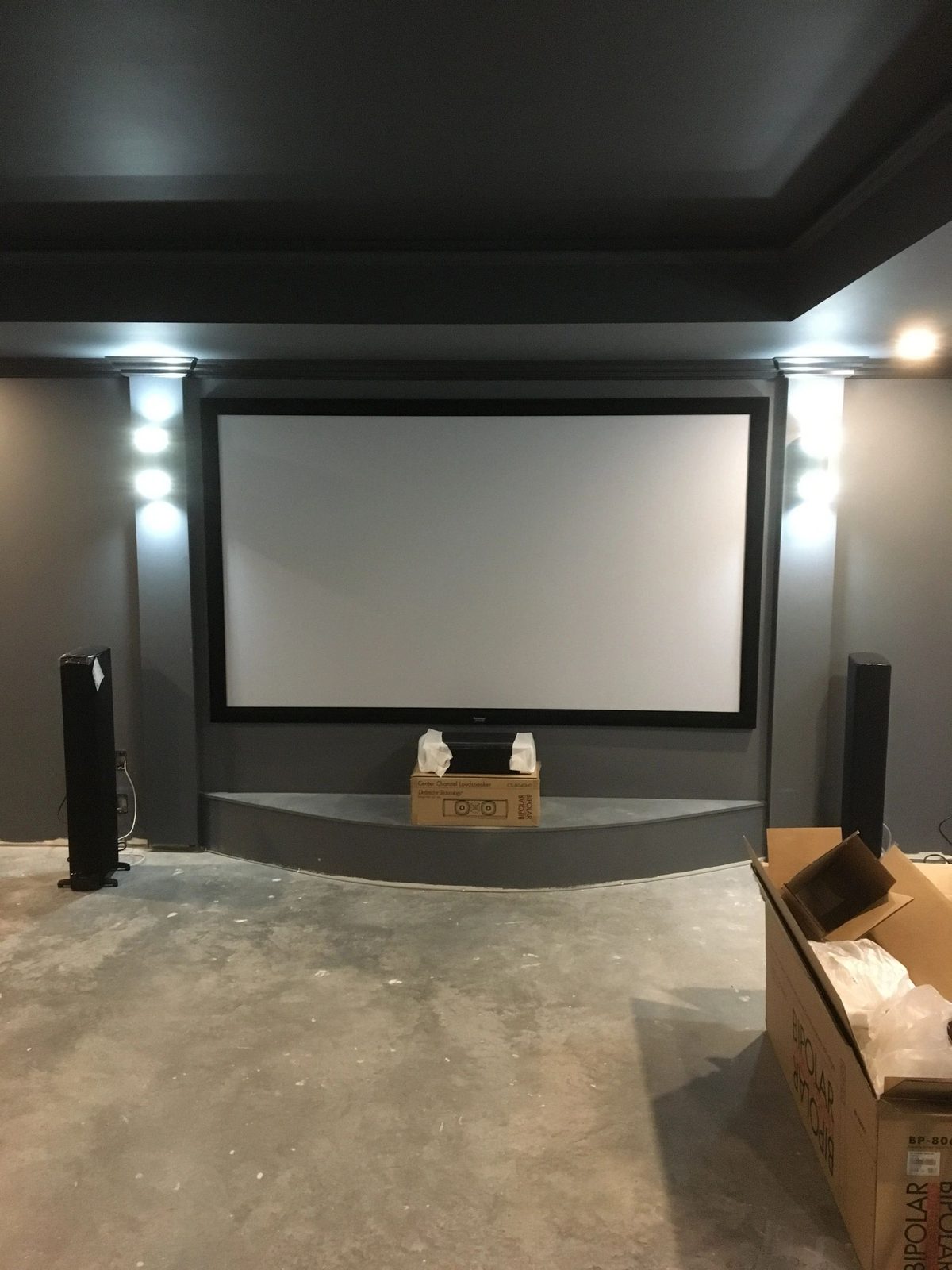 Projector screen installation with floor standing speakers