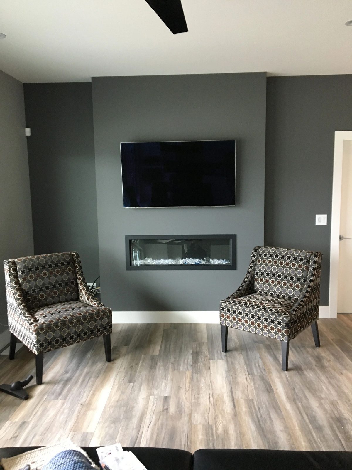 TV mounted above a linear gas fireplace on a grey feature wall