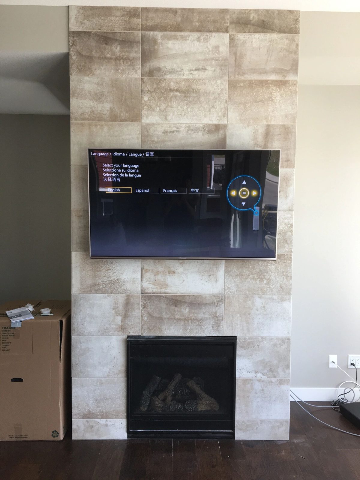 TV mounted on a travertine feature wall above a linear fireplace