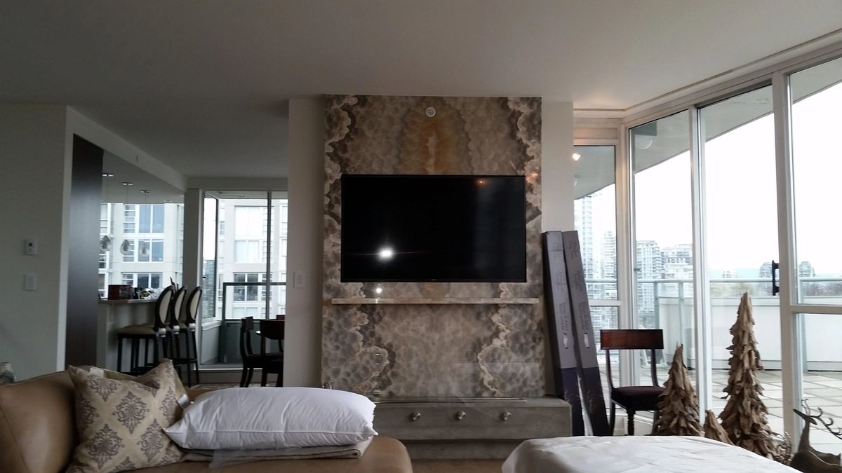 TV mounted above an ornate stone fireplace