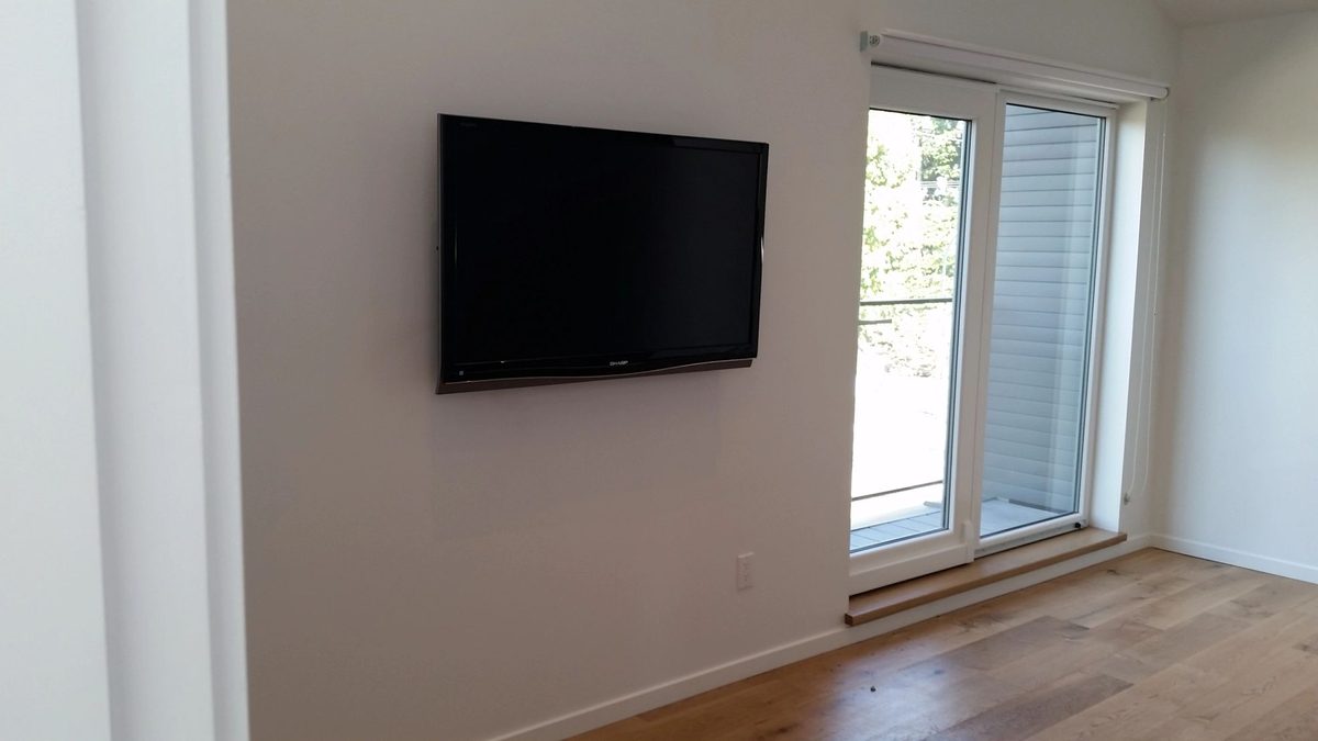 TV mounted in a corner of a bright living room