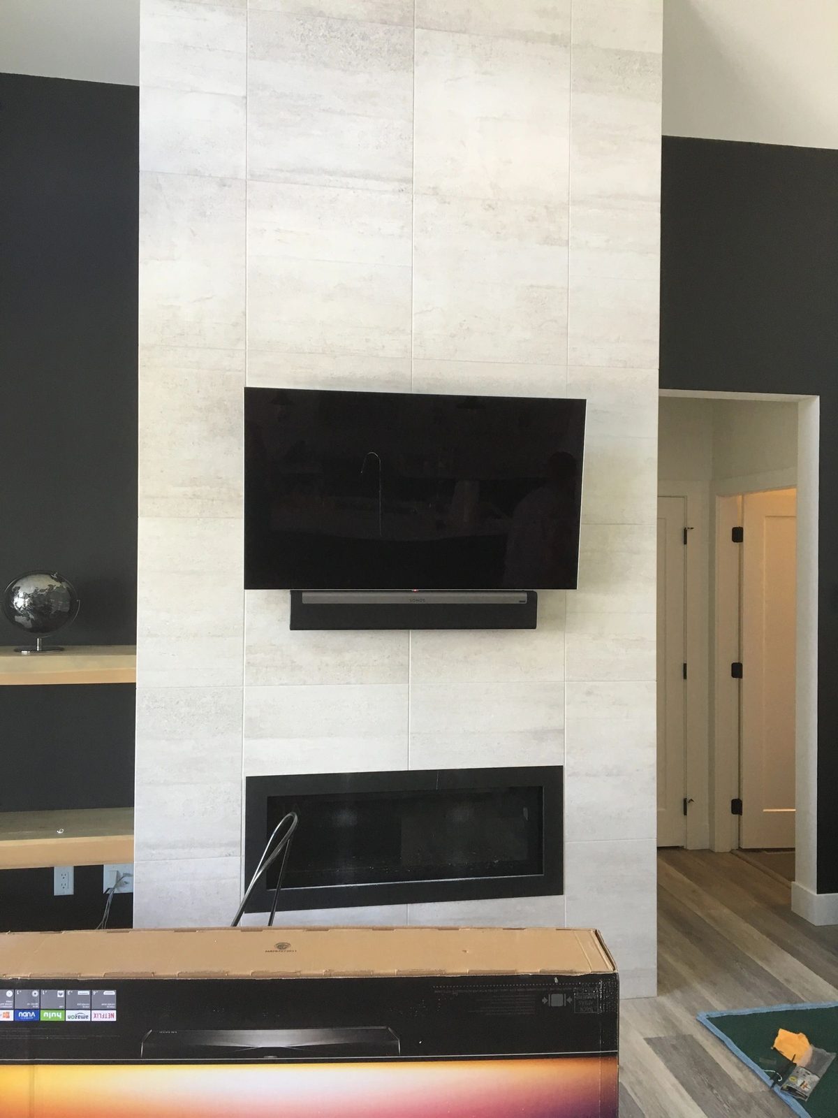 TV and Sonos soundbar mounted on a travertine fireplace wall in Kelowna