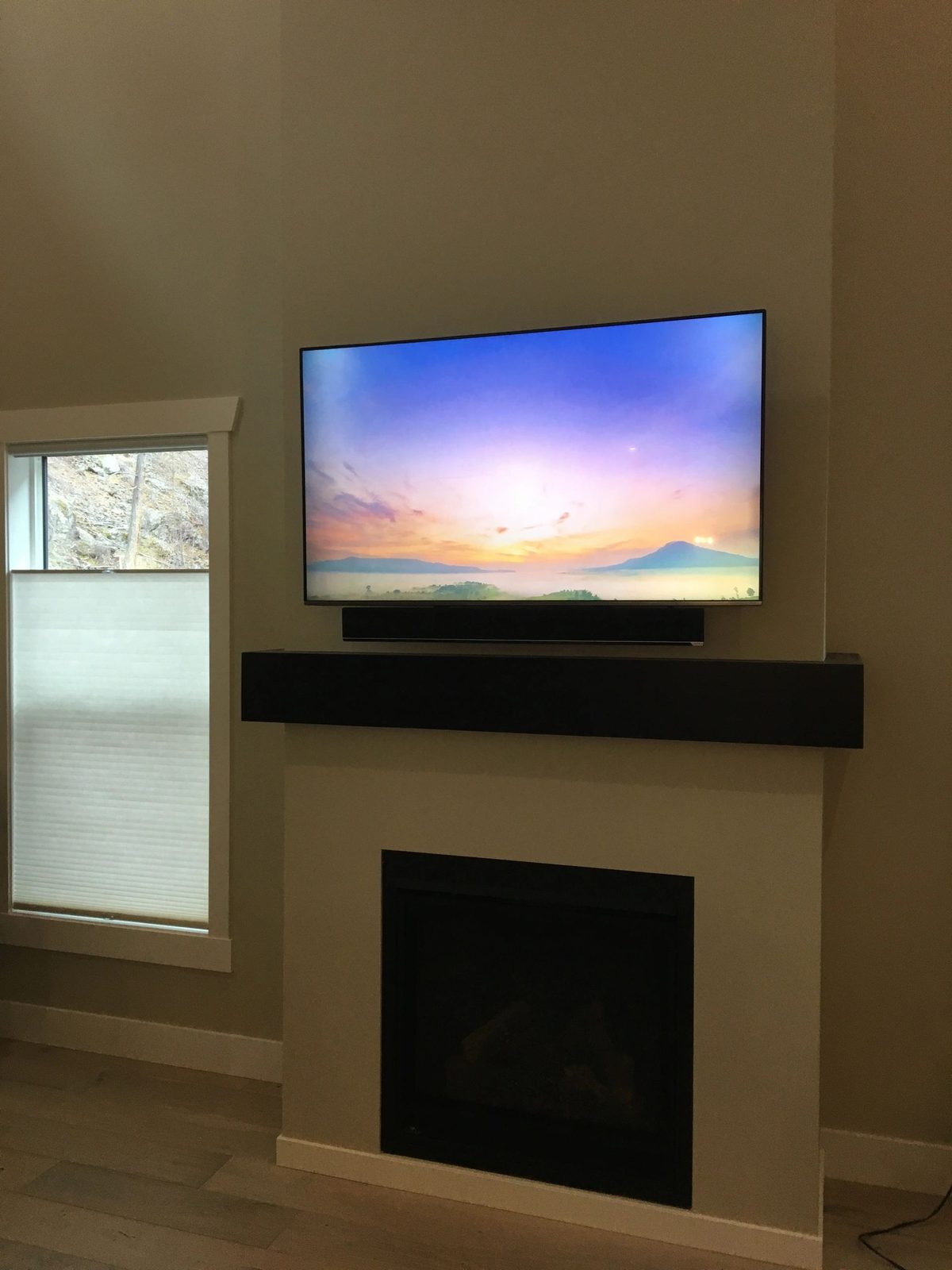 Large TV with a black soundbar mounted below it