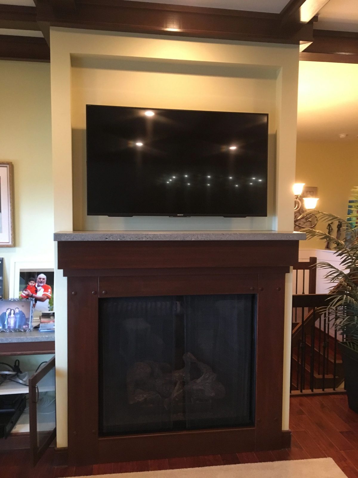 TV mounted above a traditional fireplace with timber mantle
