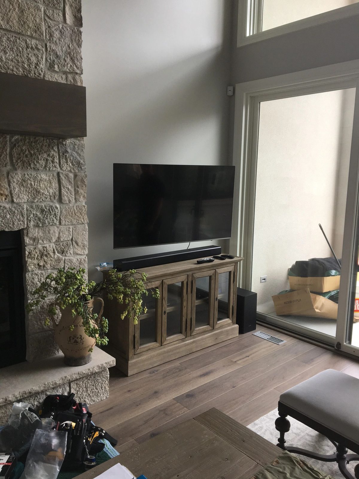 Stone fireplace wall with mounted TV and media console