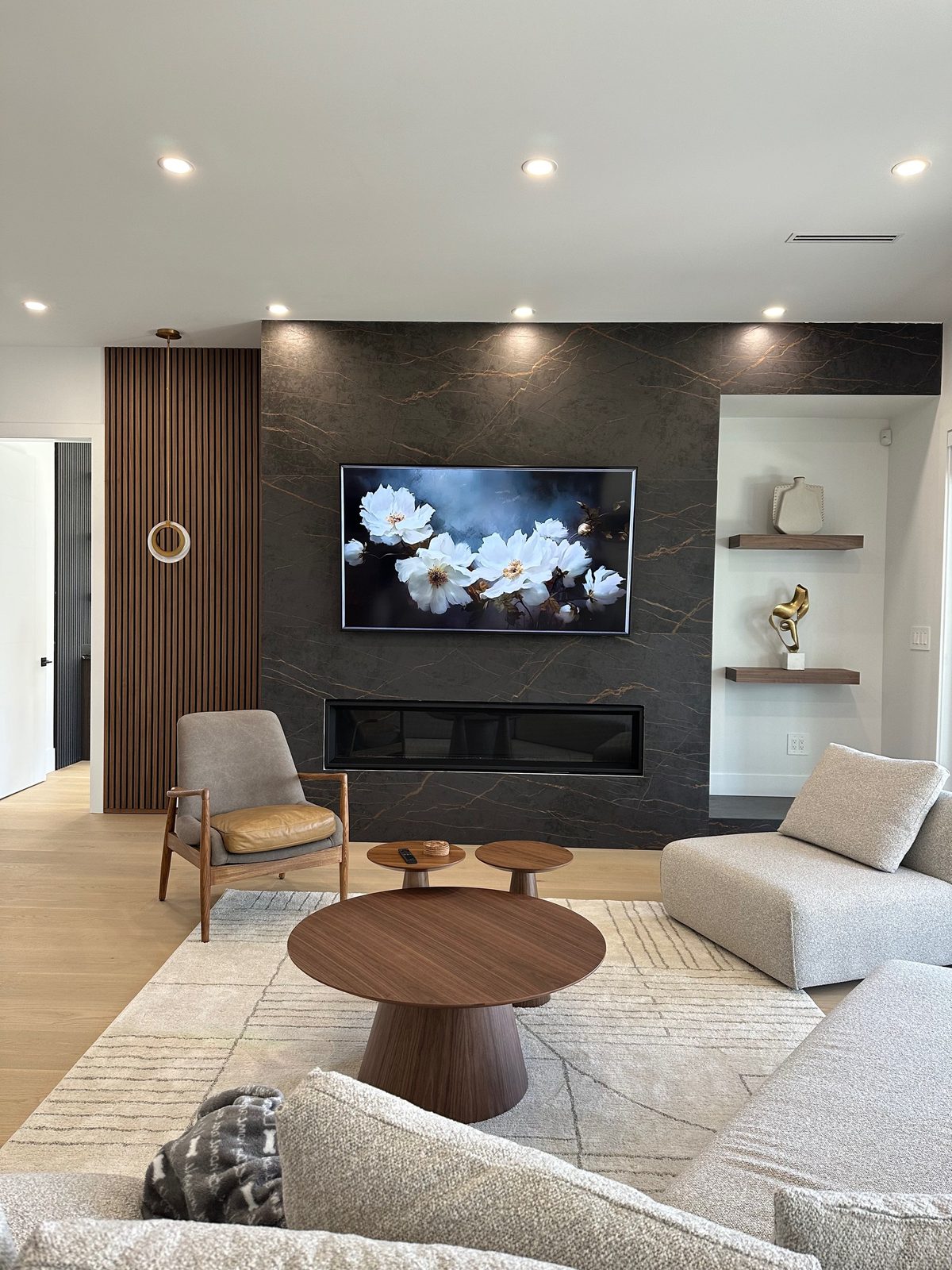 TV mounted on a dark veined porcelain feature wall above a linear fireplace