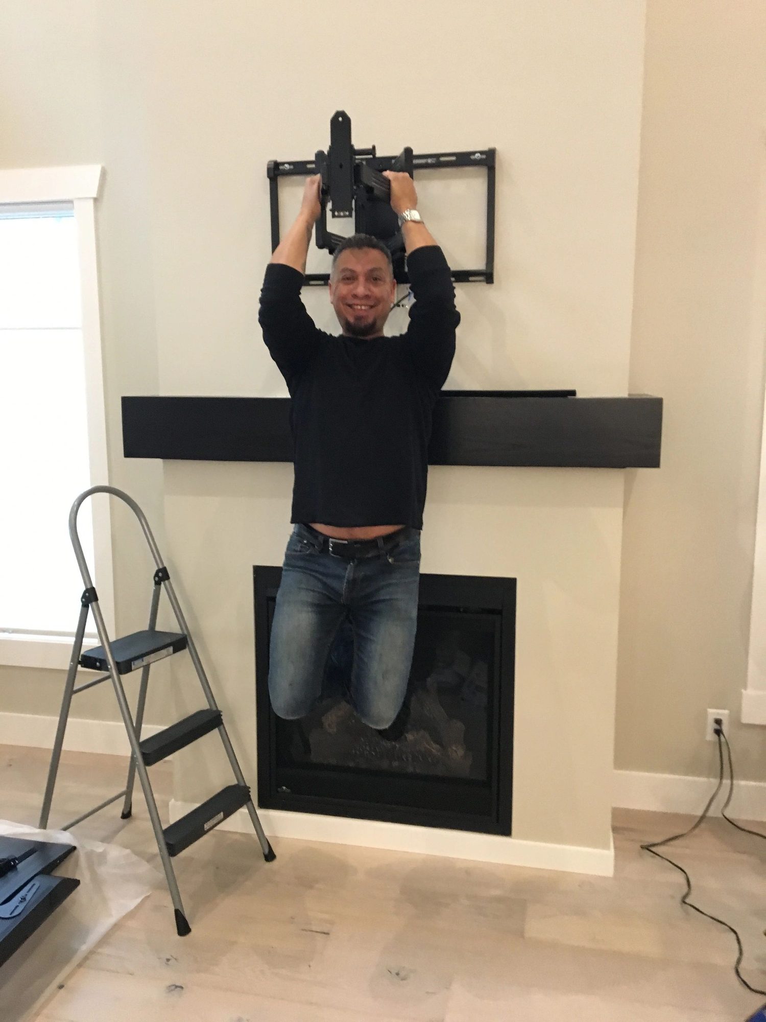 Wil Martinez hanging his full body weight from a TV mount he installed in a Kelowna home